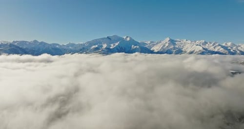Snowy Mountain Peaks Rising Above Sea Of Clouds