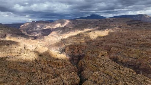 Aerial view of canyon and mountains under dramatic sky, United States.