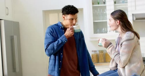 Young Couple Enjoying Coffee in Bright Kitchen