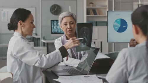 Medical Team Discussing X-Ray in Meeting