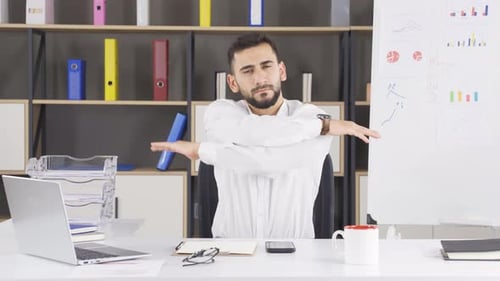 Corporate Man Doing Shoulder Stretch at Desk