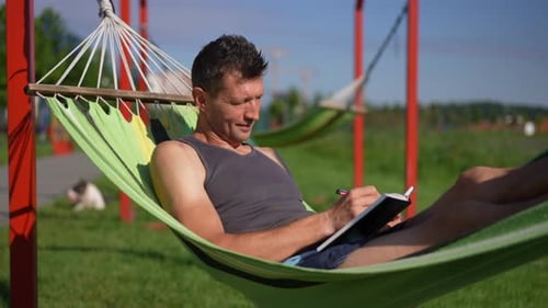 Side View Positive Smiling Adult Man Writing Diary As Live Camera Zoom in Portrait of Confident