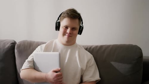 Young Adult Sitting with Laptop and Headphones