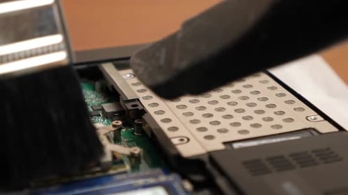 Cleaning a Laptop Circuit Board with Brush and Vacuum