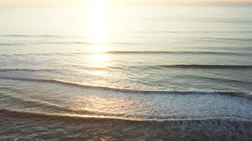 Scenic View of Sea Waves Moving on Beach Shore at Sunset