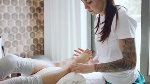 Woman giving foot massage at a modern spa
