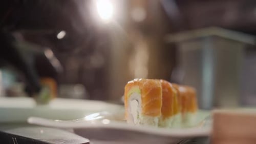 Hands Preparing Sushi Rolls in Restaurant Kitchen