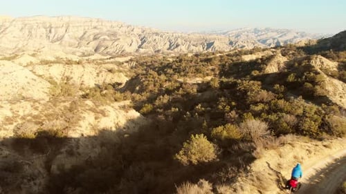 Cyclist on Desert Trail During a Sunny Day