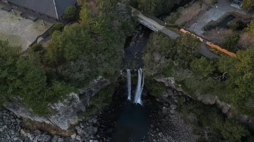 Vista aérea de drone na Coreia do Sul voando em frente a uma cachoeira sobre a área rochosa do mar para trás je