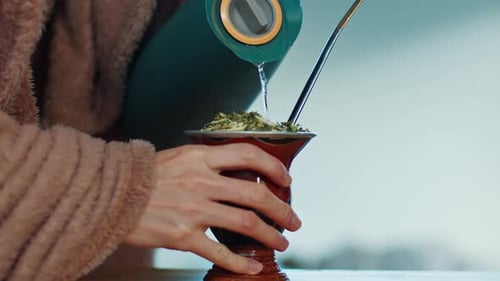 Pouring Hot Water for Traditional Mate Beverage
