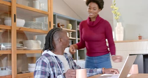 Woman Brings Coffee to Man Working on Laptop