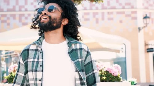 Stylish Man with Curly Hair Posing Outdoors