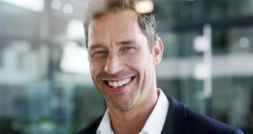 4k video footage of a cheerful young businessman in his office at work