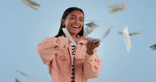 Happy woman, money rain and financial freedom with savings or winning against a studio background