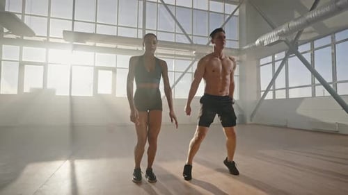 Athletic Man and Woman Doing Squats Together