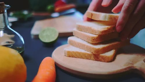 Hands Stack Sliced Bread on Cutting Board