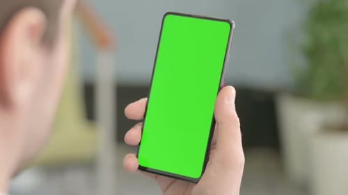 Nahaufnahme einer Hand mit einem Greenscreen-Telefon