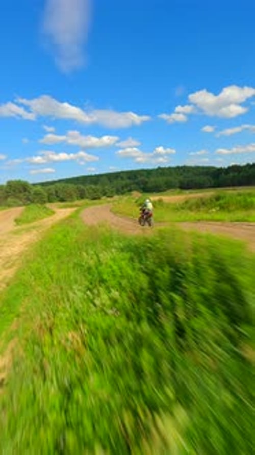Motocross Rider Racing on Rural Dirt Track