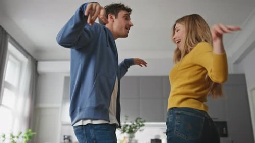 Young Couple Joyfully Dancing Together Indoors