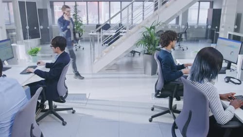 Diverse professionals work at computers in modern office