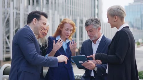 Überraschte Geschäftsleute schauen im Freien auf den Bildschirm eines Tablets