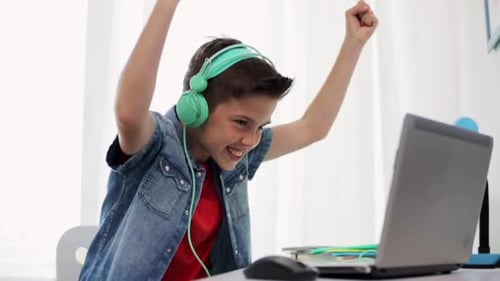 Conceito de Tecnologia, Jogos e Pessoas - Garoto em fones de ouvido jogando videogame