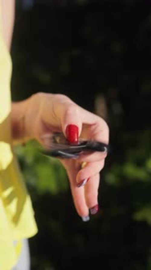 Une personne appréciant et tenant un fidget spinner coloré sous la lumière du soleil haute définition
