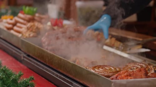 Street Vendor is Preparing Sausages on Grill at Christmas Market