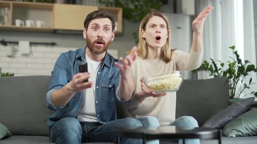 Exited couple sport fans watch football together and celebrating win goal score of match game