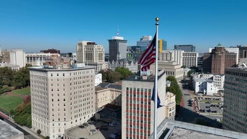 American Flag Waving Over City Skyline on Sunny Day