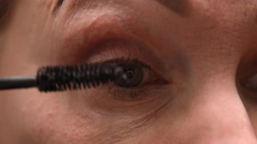 Woman Applying Mascara with Applicator Wand