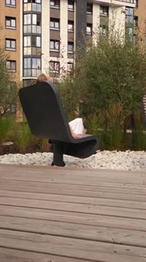 Heureuse jeune femme assise sur un banc rotatif
