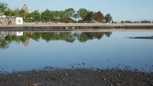 Still Water Reflecting Urban Landscape in Daytime