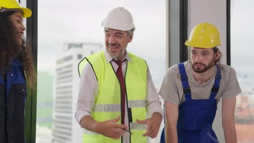 Construction Workers Reviewing Plans in City Skyscraper