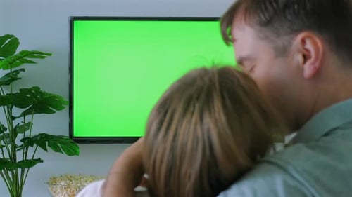 Couple Enjoying Cozy Movie Night at Home with Green Screen TV Showing
