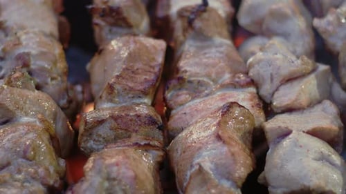 Delicious juicy meat cooking over glowing hot coals