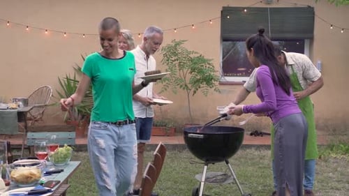 Friends Enjoying Barbecue in Backyard on Summer Day