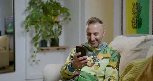 Man Relaxing at Home Using Mobile Phone
