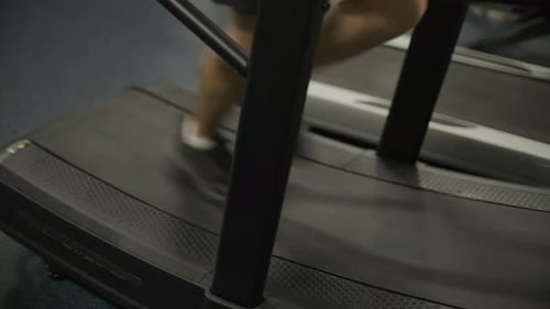 Muscular Man Running on Treadmill during Training Session in Gym