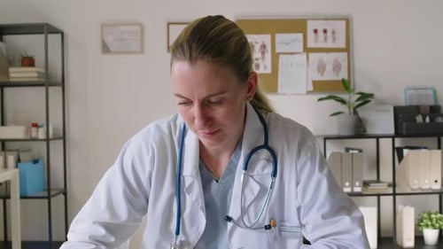 Portrait of Smiling Middle-Aged Caucasian Female Physician Working in Office
