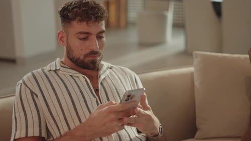Man Relaxing at Home Using Mobile Phone