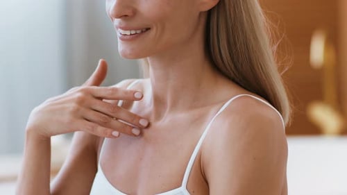 Woman Applying Moisturizer to Neck and Shoulder