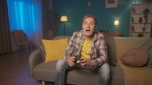 Excited Man Playing Video Games on Couch