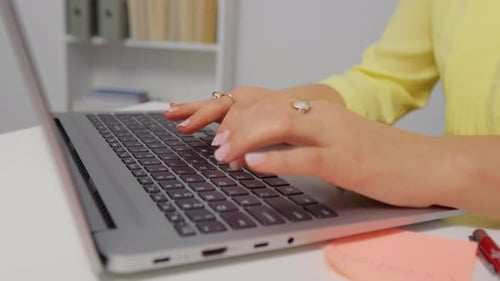 Close up hands of woman typing on laptop email in home office.