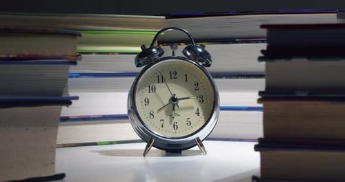 Alarm Clock Surrounded By Time Lapse Books