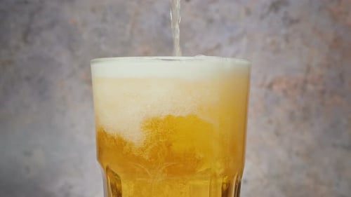 Refreshing Beer Pouring into Glass Close Up