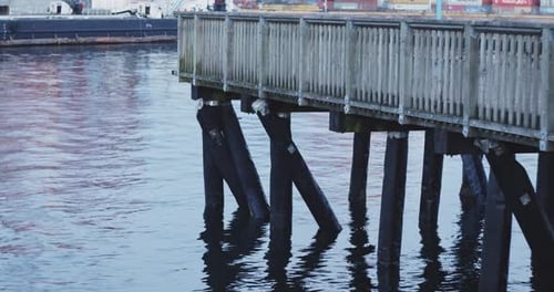 Holzsteg über Wasser mit Wellen.