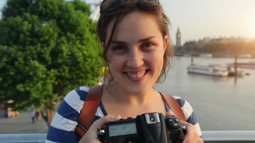 4k video footage of a young woman taking pictures with a camera while exploring a city