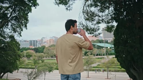 Tranquil Man Drinking Coffee in Green Park Back View Relaxed Guy Enjoy Beverage