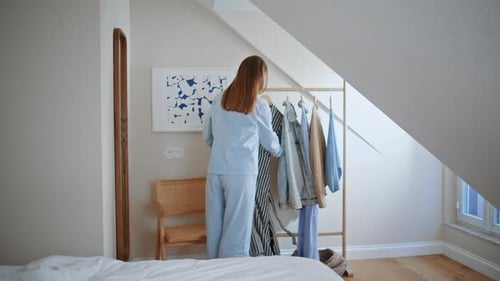 Woman in Pajamas Choosing Clothes in Bedroom